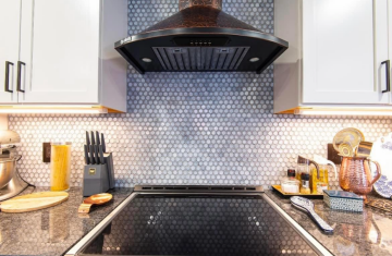 Intricate title work as a back splash and behind the stove range hood.
