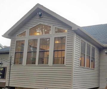 A house with tan siding; construction work done by ATM Contracting LLC.
