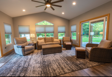 The interior renovation work of ATM Contracting LLC showing a living room that has multiple windows and a sliding door.