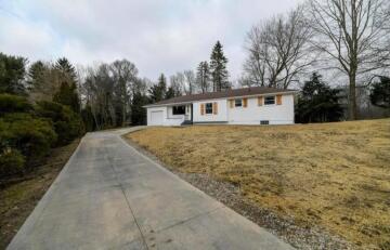 A white house modernized by ATM Contracting LLC's siding work.