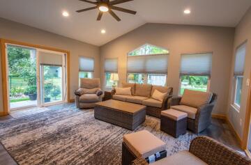 Another view of the living room with multiple windows and two sliding doors.