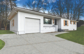 A white house and garage with siding and wood window trims remodeled by ATM Contracting LLC.