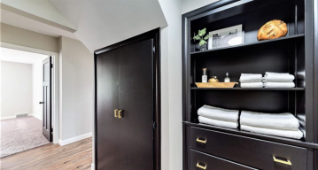 An open black shelve with drawers under it that is built into the wall beside a closet with black doors showing the work of ATM Contracting LLC.