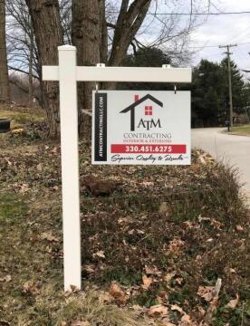 A post with a sign for ATM Contracting Interior and Exterior.